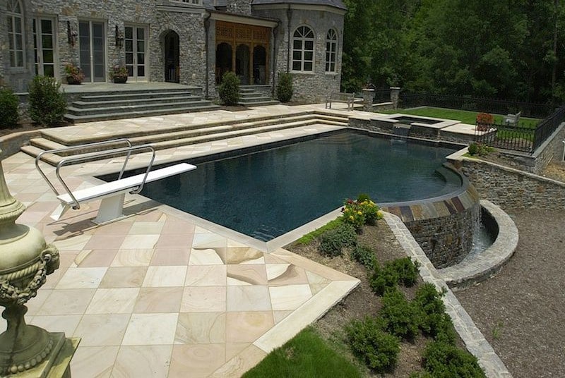 a close up of a stone building that has grass and trees