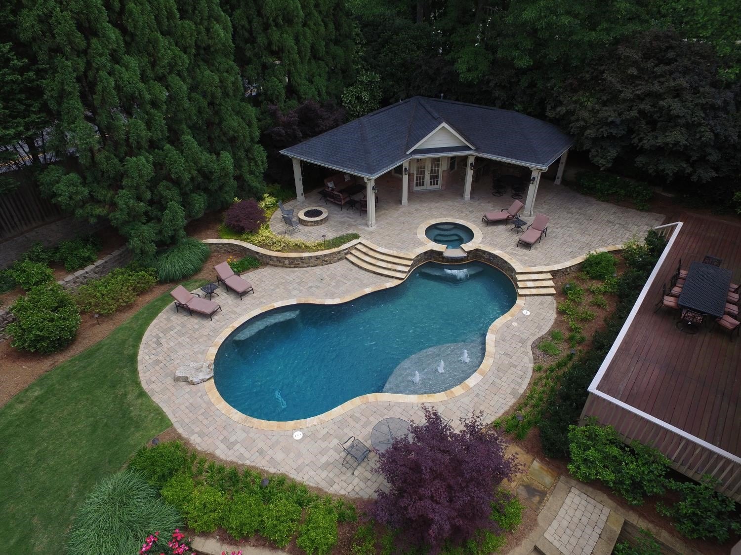 a pool with grass and trees